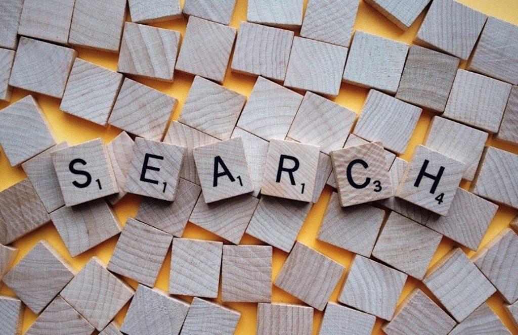 Letters on wood tiles spell out SEARCH